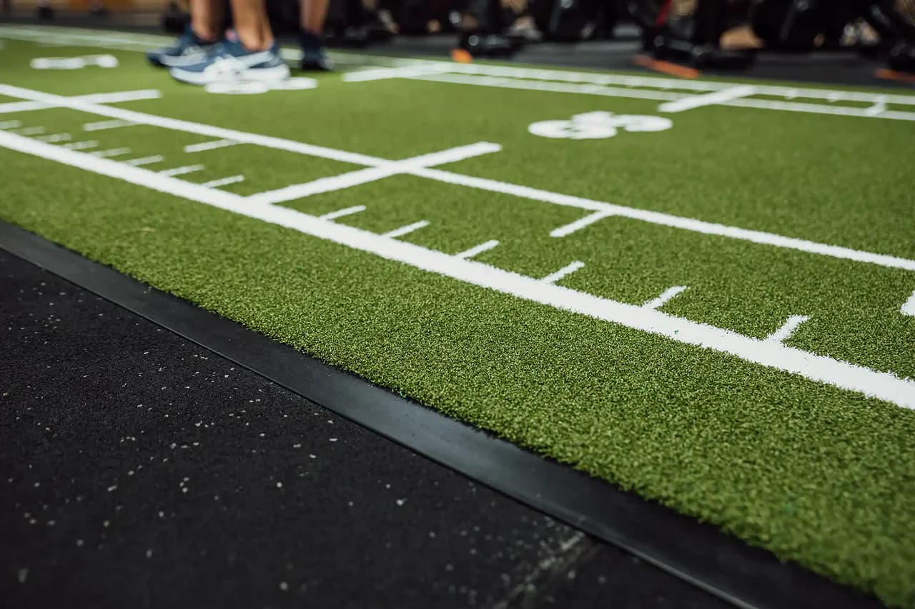 Gros plan d'une piste sled verte Heroturfs avec marquages blancs dans une salle
