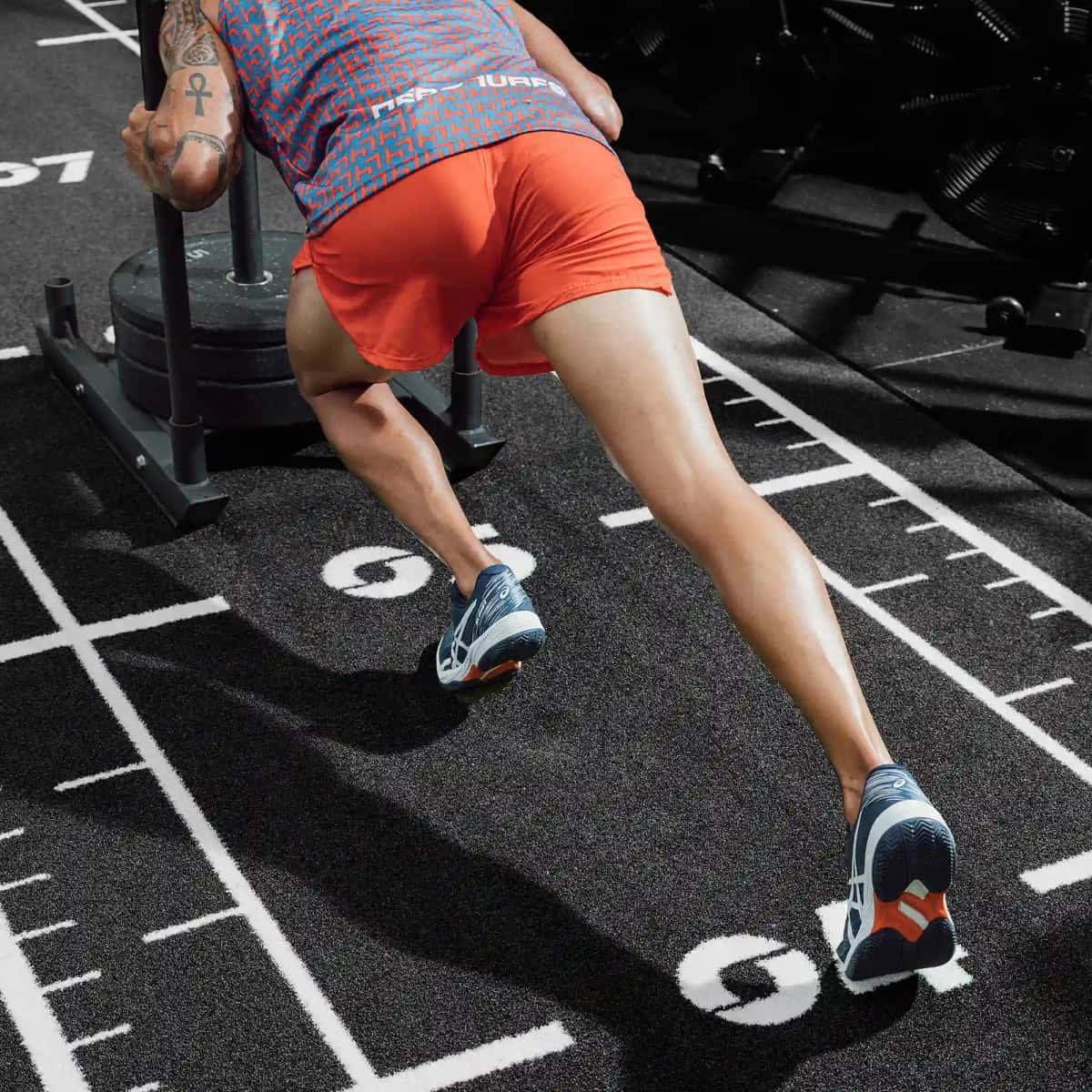 Traînées et poussées de traîneau sur gazon artificiel en salle de sport